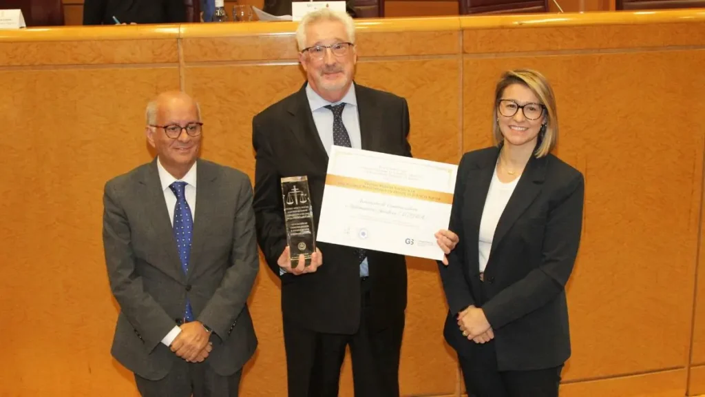 El presidente de ACIJUR, Xavier Gil Pecharromán, recoge el 'Premio Mérito Social' de manos de Joaquín Merchán, presidente del CGCOGSE, y de Teresa Silleras, presidenta del CGSM